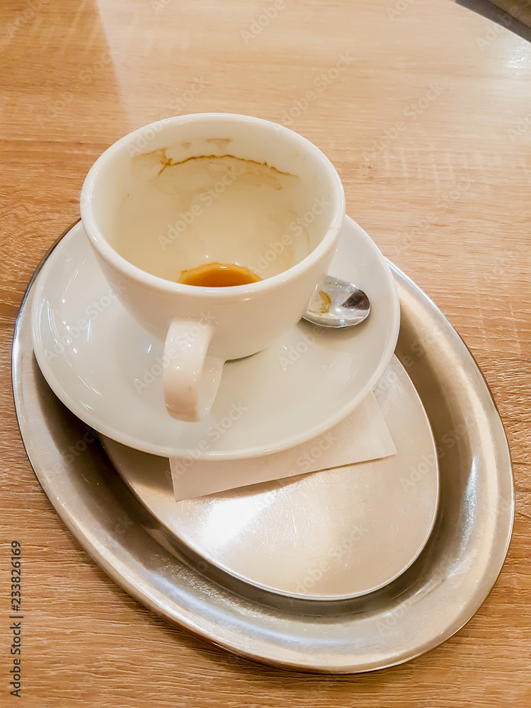 Obraz premium Verzehrter Kaffee leere Tasse auf Silber Tablett