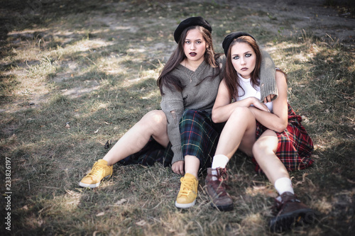 Two girls spend time together outdoors. The concept of difficult teenagers  bad students. Representatives of youth subcultures