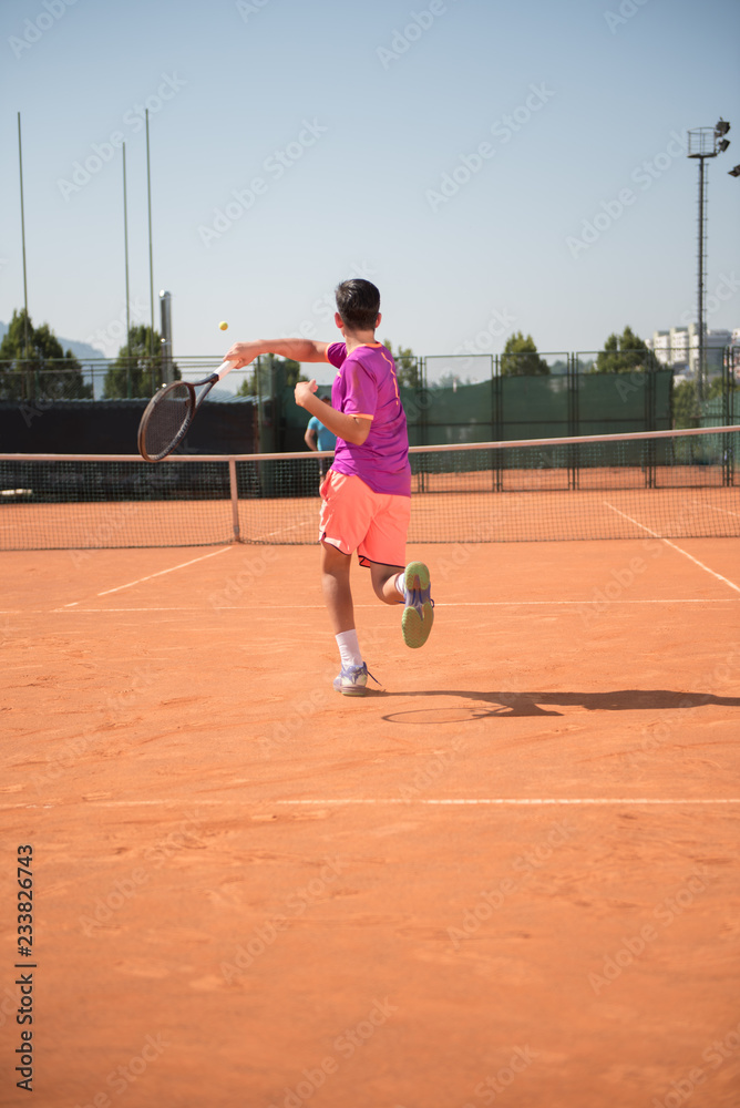 Young tennis player playing forehand