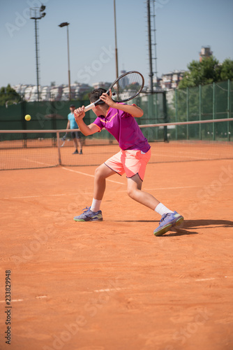 Young tennis player playing backhand