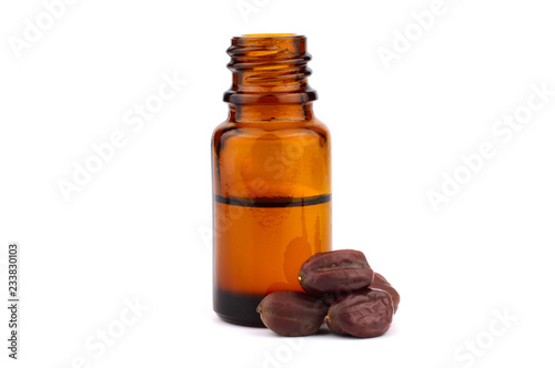 Jojoba Oil in a Bottle with Seeds (Simmondsia Chinensis). Isolated on White Background.
