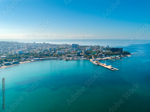 Bird's eye view of the sandy beach, the sea, the seaside coastal town and the pier.