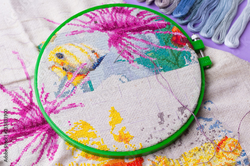 The process of working on a piece of embroidery.