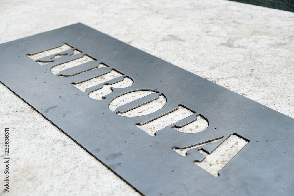 Fototapeta premium Metal label un marble with name of the continent Europe. Close up detail.