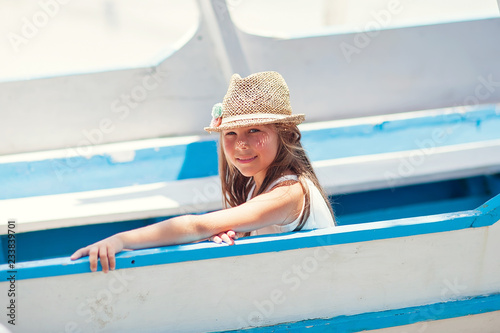 Girl child on a sail boat has a vacation on a ocean