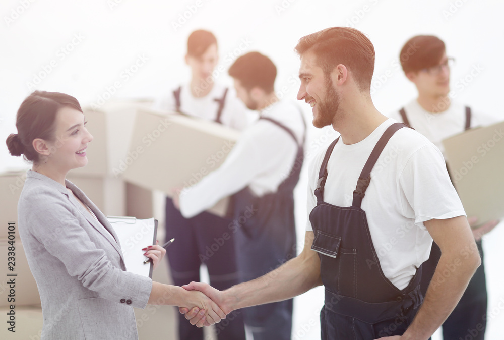 Manager with clipboard shaking hands with movers. Manager with clipboard shaking hands with movers.