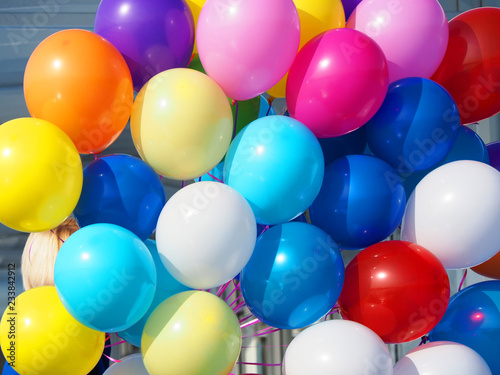 Girl hidden by a bunch of colorful balls. Holiday good day, background happy, balloons