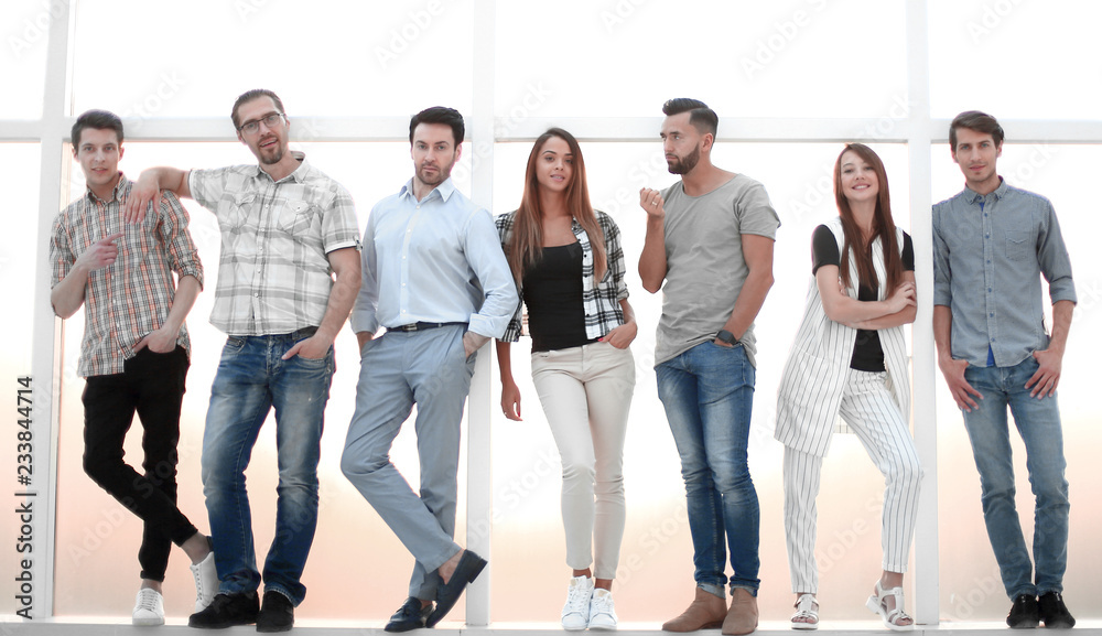 Fototapeta premium group of young people standing near a large window