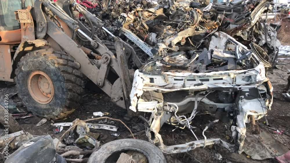Junk yard cars lifted up into air by bulldozers forklift before reversed towards sunlight. Junk yard cars lifted up into air by bulldozers forklift before reversed towards sunlight.
