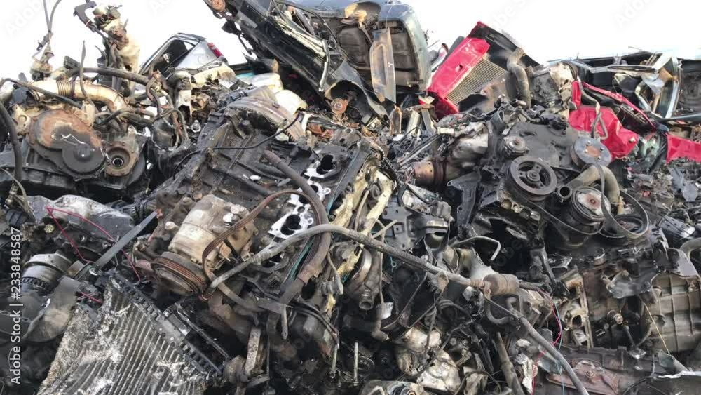 Salvage yard engines pan of steel and metal piled for motor recycling at later date.  