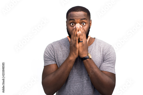 Allergic reaction to smells, a man sneezes, allergy symptoms, African American on a white background in the studio, freestyle emotions on the background. Advertising for allergy drugs