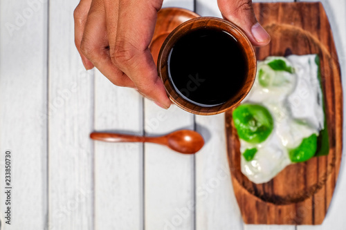 Badak berendam a local Malaysian dessert and cuf of coffee  on wooden background photo
