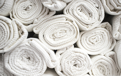 Loads of rolled white cotton bedspreads