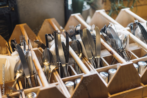 Forks, knifes and spoons in restaurants interior. Kitchenwear in close up, ready to service.