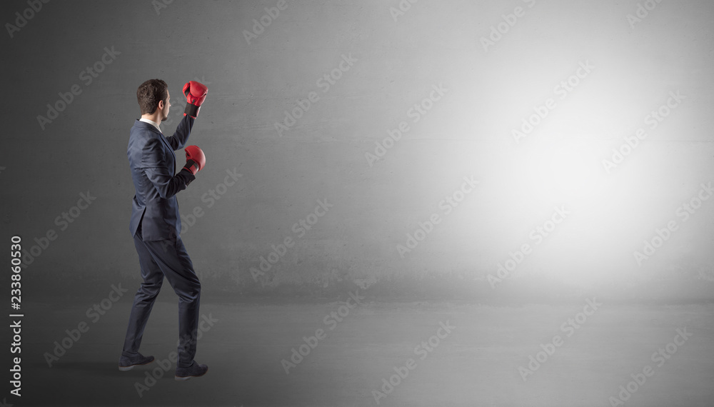 Businessman fighting with boxing gloves in an empty space
Businessman fighting with boxing gloves in an empty space