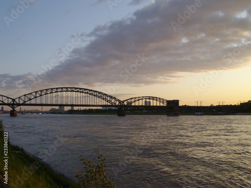 Sonnenaufgang / Sonnenuntergang über dem Fluss (Rhein) und der Kölner Südbrücke