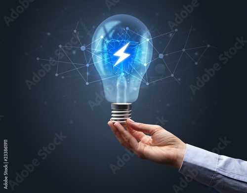 Hand holding light bulb on dark background. Networking idea concept