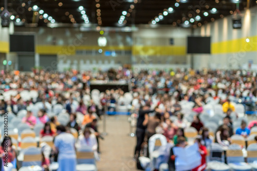 Abstract blurred photo of conference hall or seminar room in Exhibition Center with speakers on the stage and attendee background, seminar and study concept © THANANIT