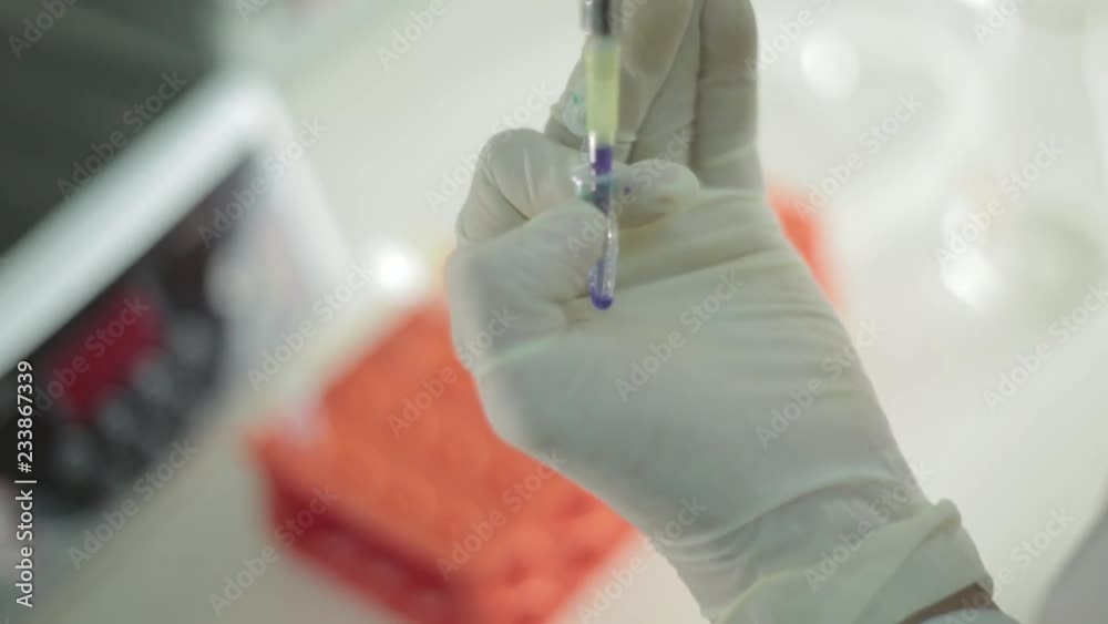 Liquid being extracted in laboratory with blurred background Liquid being extracted in laboratory with blurred background