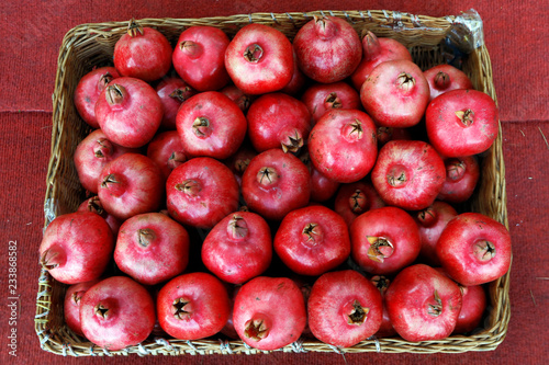 A lot of ripe pomegranates in a basket after harvest.