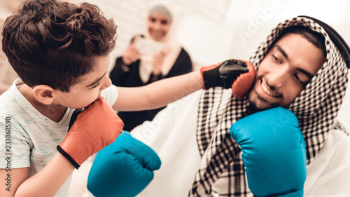 Arabian Boy Boxing with Young Father at Home.