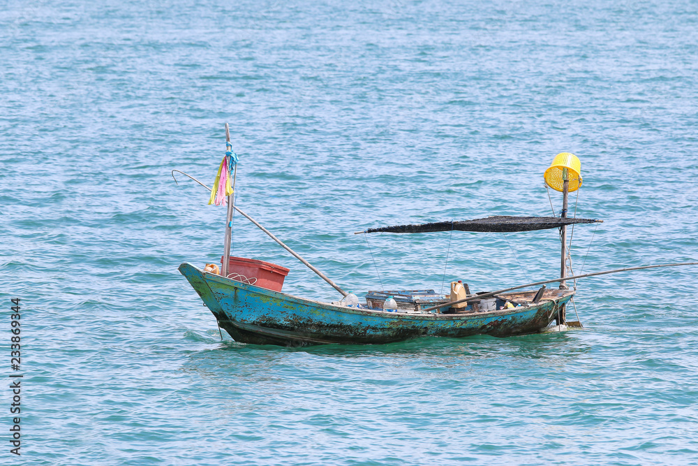 Fishing boat floating on the water, blue sea with copyspace Fishing boat floating on the water, blue sea with copyspace