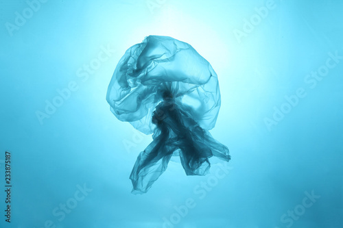 Drifting plastic bag in the form of a jellyfish in the world ocean. Concept of technogenic pollution of the planet. photo