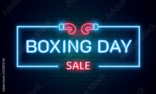 Neon text Boxing Day sale on brick wall background for advertising or promotion concept.