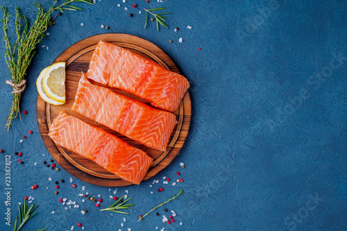 Fotografie Food background, sliced portions large salmon fillet steaks on chopping board on