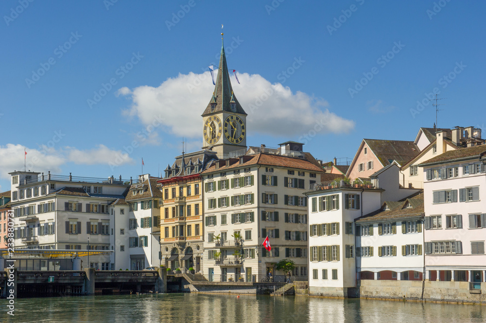 the St. Peter Church tower  and old houses along the Limmat river, Zurich, Switzerland
