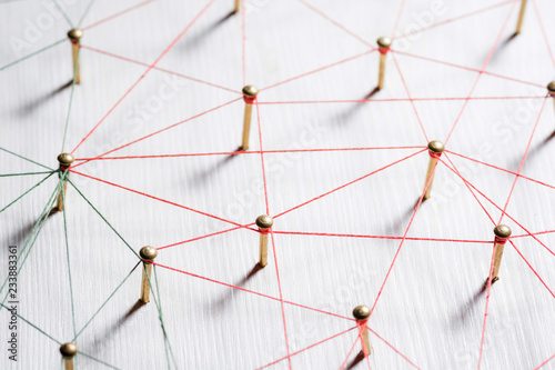 Linking entities. Network, networking, social media, internet communication abstract. A small network connected to a larger network. Web of gold wires on white wooden background. Network hub or key photo