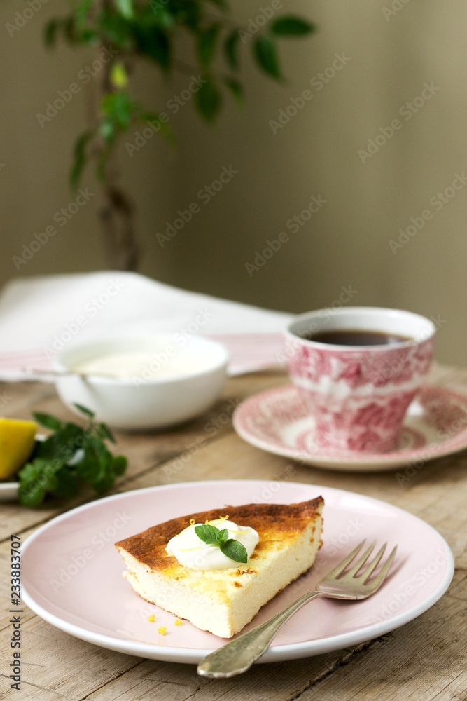 Healthy breakfast made from soft cottage cheese casserole with oatmeal and lemon zest, served with sour cream and mint.