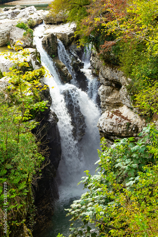Fototapeta premium Amazing view on waterfall in the picturesque Martvili canyon in Georgia near Kutaisi. Beautiful natural canyon with view of the mountain river, christal blue water and boat ride.