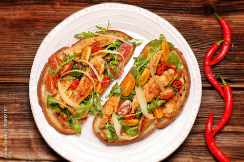 Chicken sandwich on fresh bread with arugula tomato and cheese