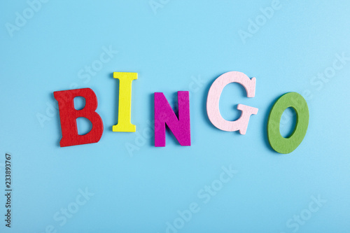 The word bingo made of wooden letters on blue background.