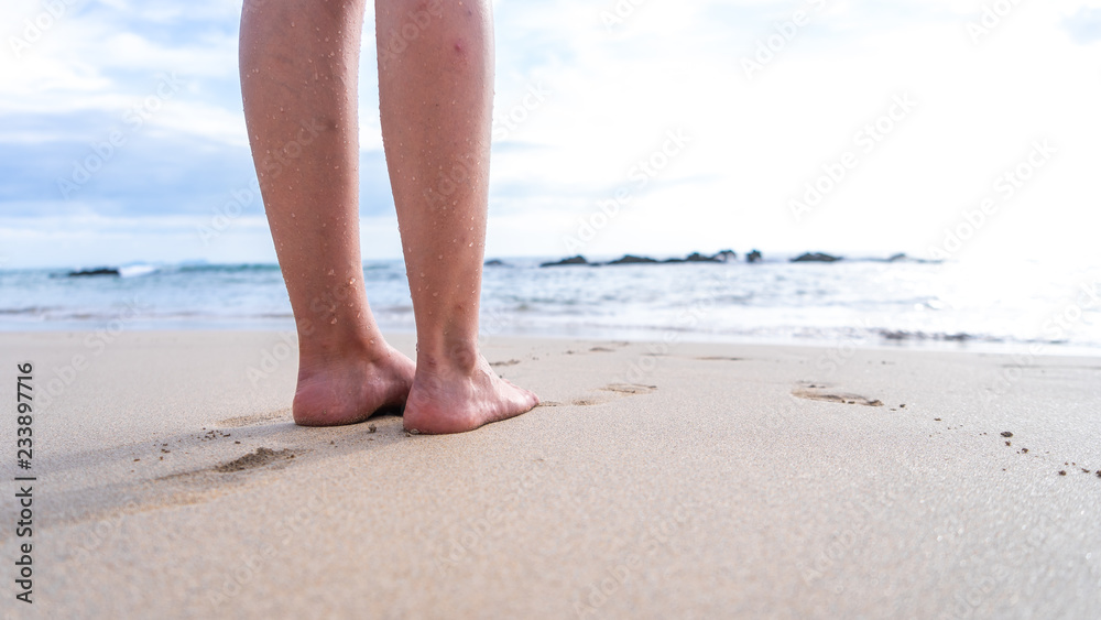 Womans Feet and Legs in the sand looking out to the sea in Thailand Womans Feet and Legs in the sand looking out to the sea in Thailand