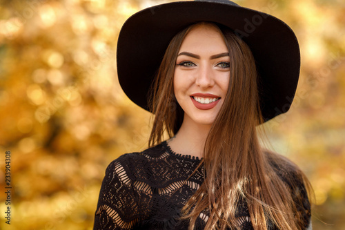 beautiful woman in black dress and hat in autumn © producer