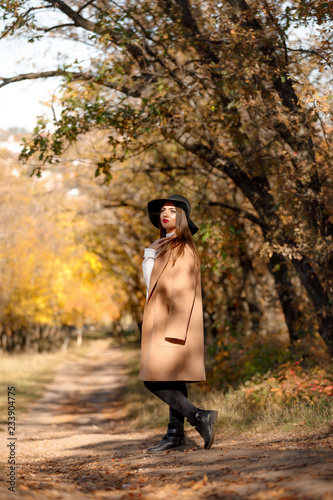 beautiful young woman in coat and black hat