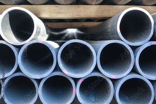 Stacks of black plastic pipes. Round ends close up.