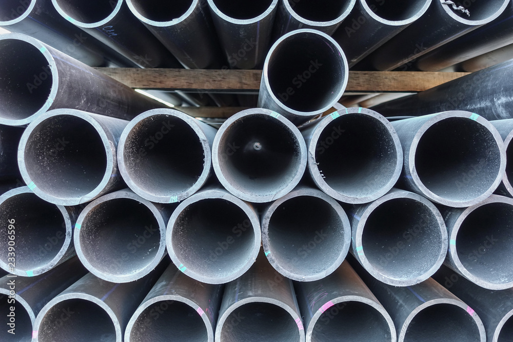 Stacks of black plastic pipes. Round ends close up. Stacks of black plastic pipes. Round ends close up.
