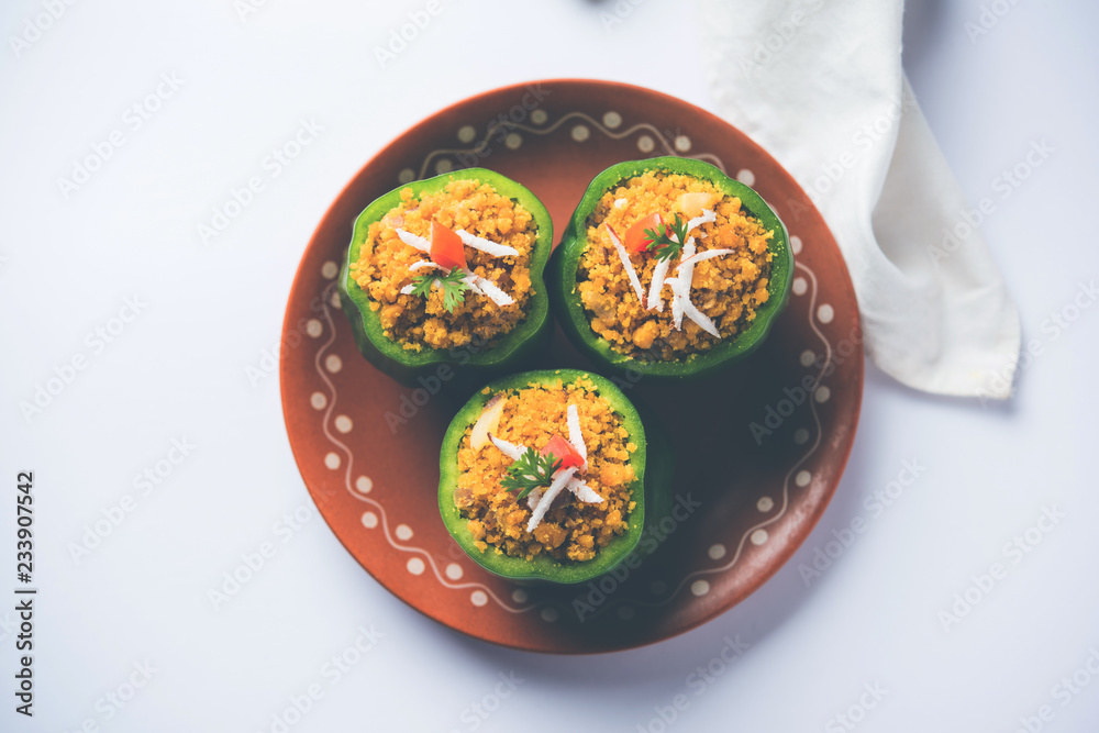 Stuffed capsicum or bharwa shimla mirchi is a popular Indian main course recipe. Served in a plate over moody background. Selective focus Stuffed capsicum or bharwa shimla mirchi is a popular Indian main course recipe. Served in a plate over moody background. Selective focus