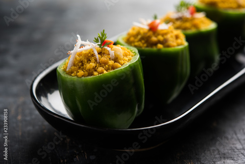 Stuffed capsicum or bharwa shimla mirchi is a popular Indian main course recipe. Served in a plate over moody background. Selective focus photo