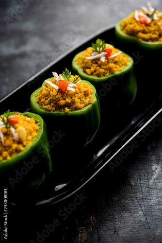 Stuffed capsicum or bharwa shimla mirchi is a popular Indian main course recipe. Served in a plate over moody background. Selective focus