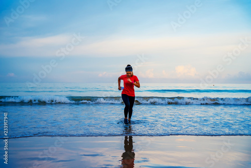 Girl running workout jogging on the beach in the morning. relax and happy with running on the sea. in summer