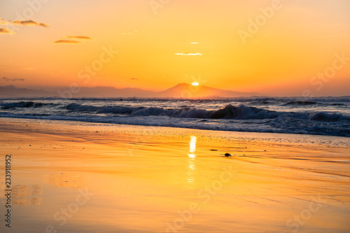 Shiny orange sunset on a beach in Biarritz with view on the coast. Basque country of France.