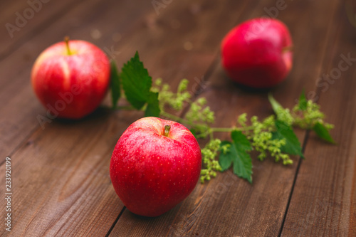 Ripe juicy apples of red color on a wooden table