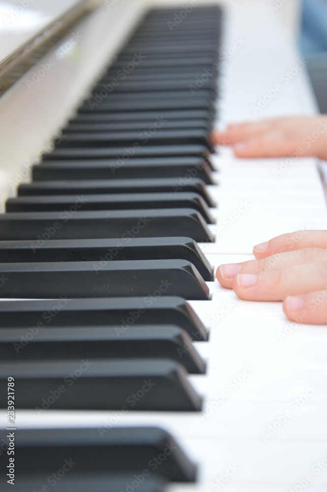 Fototapeta premium First piano lessons for a little child. First steps at beginner level
