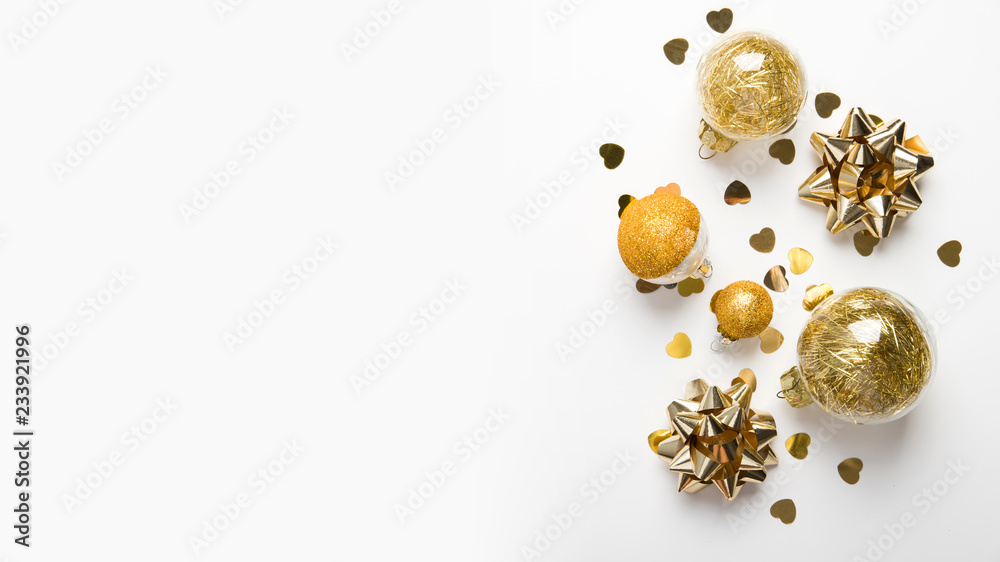 Fototapeta premium Merry Christmas and Happy Holidays greeting card. New Year. Golden ornaments on white background top view. Winter holidays.