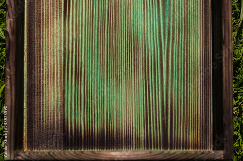 Burnt bottom of a wooden green box close up photo