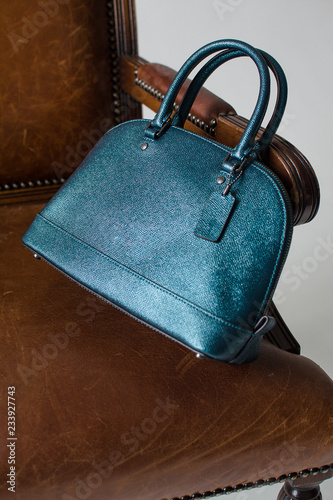 women's leather bag on a brown chair without logo, advertising shooting bags, presentation bags, leather handbag.